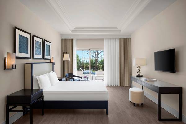 Schlafzimmer im IC Santai Family Resort mit großem Bett, Nachttischen, Fernseher und Schreibtisch.