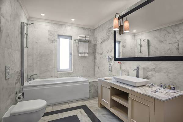 IC Santai Family Resort Badezimmer mit Badewanne, Waschbecken, Spiegel und Toilette.