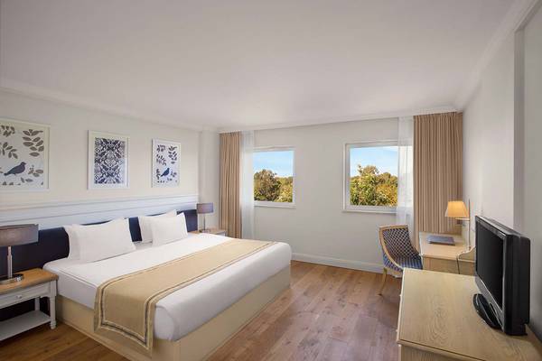 IC Santai Family Resort Hotelzimmer mit Doppelbett, Fenstern und Fernseher.
