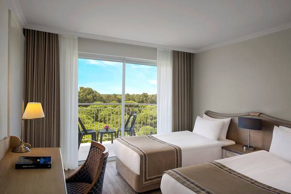 Doppelzimmer im IC Santai Family Resort mit Blick auf den Garten vom Balkon.