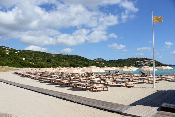 Strand des Abi d'Oru Beach Hotel & Spa mit vielen Sonnenschirmen und Liegen