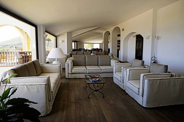 Lounge-Bereich im Abi d'Oru Beach Hotel mit weißen Möbeln und Holzboden.