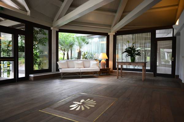 Eingangsbereich des Abi d'Oru Beach Hotel mit weißem Sofa und goldenem Logo auf dem Boden.