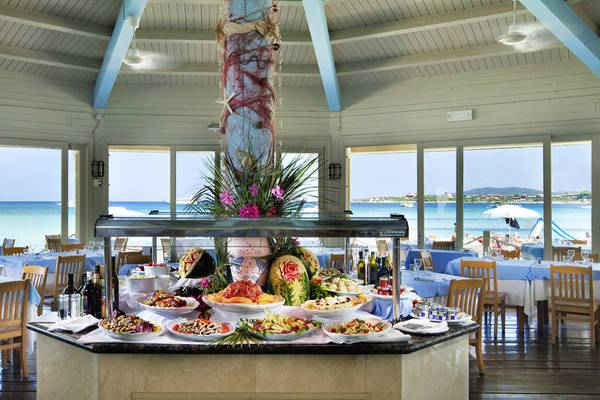 Buffet-Tisch im Abi d'Oru Beach Hotel mit Blick auf das Meer und eine sonnige Strandlandschaft.