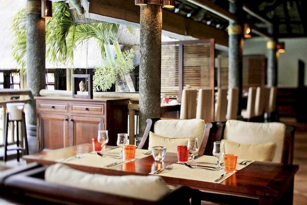 Innenbereich des Veranda Paul et Virginie Hotel mit gedeckten Tischen und Stühlen.