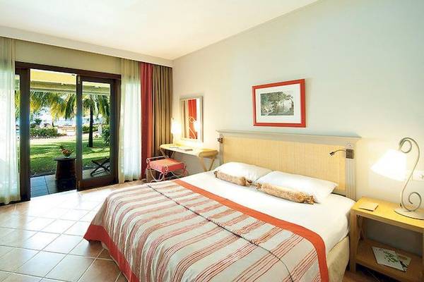 Schlafzimmer im Veranda Paul et Virginie Hotel & Spa mit Doppelbett, Nachttischen und offener Terrasse.