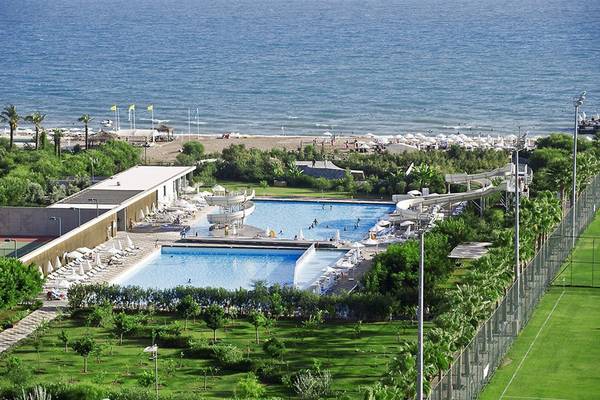 Luftaufnahme des Poolbereichs des Nirvana Cosmopolitan Hotels mit Meer und Tennisplätzen
