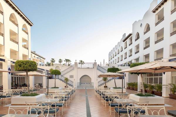 Außenbereich des MAC Puerto Marina Hotels mit geometrischen Formen und begrünten Pflanzen in Töpfen.