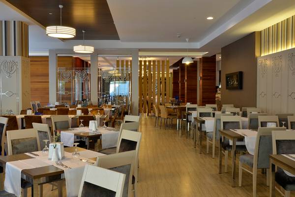 Innenansicht des Restaurants im Port Side Resort mit gedeckten Tischen und modernen Möbeln.