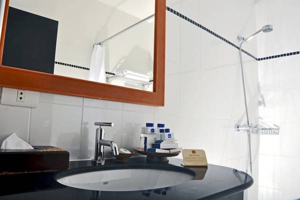 Badezimmer im Best Western Phuket Ocean Resort mit Waschbecken, Spiegel und Handtuchhalter.