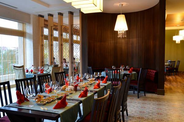 Innenansicht des Restaurants im Port Side Resort mit gedeckten Tischen und hängenden Kronleuchtern.