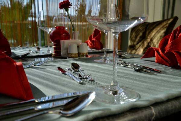 Tisch im Port Side Resort mit Geschirr und roten Servietten und Blumen.