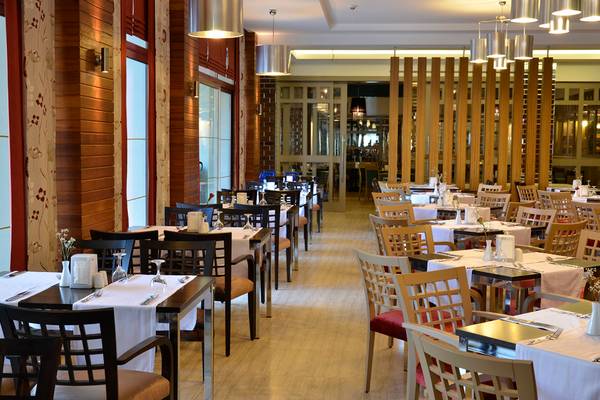 Innenansicht des Restaurants im Port Side Resort mit gedeckten Tischen und Stühlen.