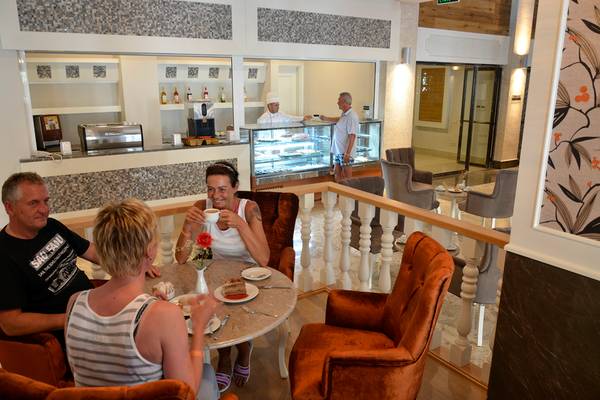 Vier Gäste im Restaurant des Port Side Resorts sitzen an einem Tisch und genießen ihr Essen.