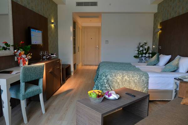Port Side Resort Hotel Zimmer mit Bett, Schreibtisch und Früchten auf Tisch