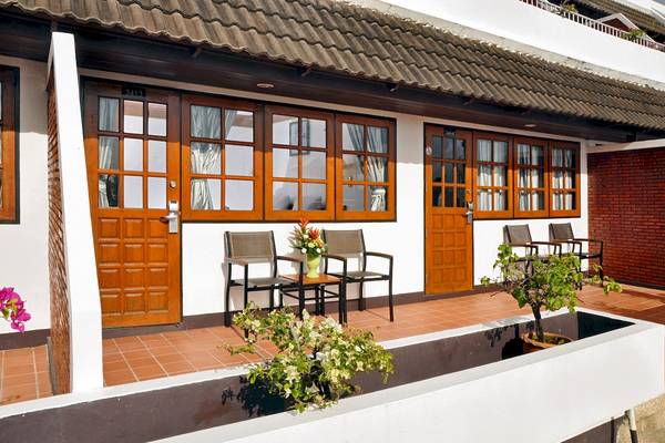 Eingang des Best Western Phuket Ocean Resorts mit zwei Türen und Bänken auf der Terrasse.