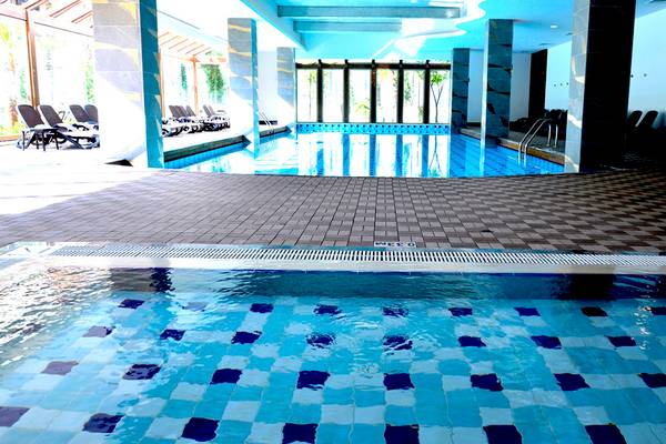 Innenpool des Port Side Resort mit blauen und weißen Fliesen und Loungebereich