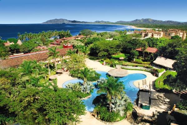 Luftaufnahme des Tamarindo Diria Beach Resorts mit Pool und Meer im Hintergrund.