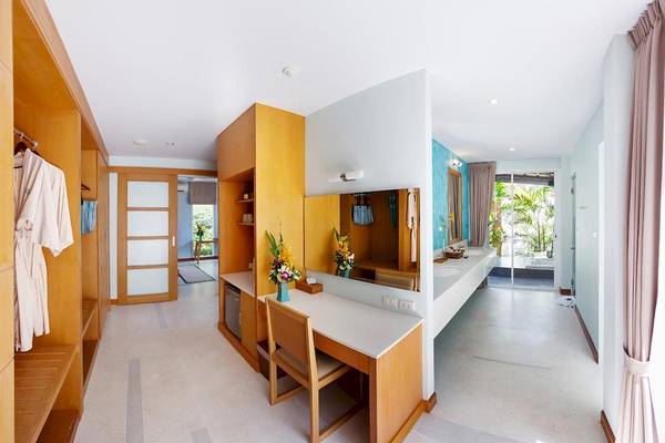 Innenansicht des Badezimmers im Apsara Beachfront Resort und Villa mit Holzmöbeln und einem Spiegel.
