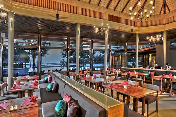 Innenansicht des Restaurants des Apsara Beachfront Resort und Villa mit modernen Möbeln und Blick auf das Meer.