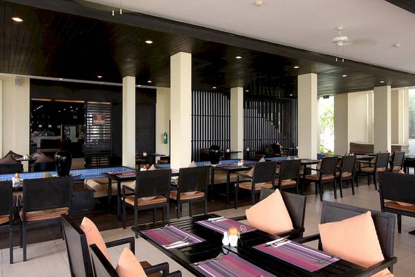 Restaurant im Apsara Beachfront Resort und Villa mit dunklen Möbeln und Deckenventilatoren