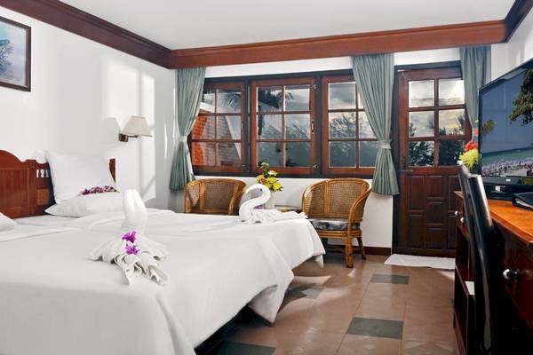 Hotelzimmer im Best Western Phuket Ocean Resort mit zwei Betten, Dekor und Möbeln.