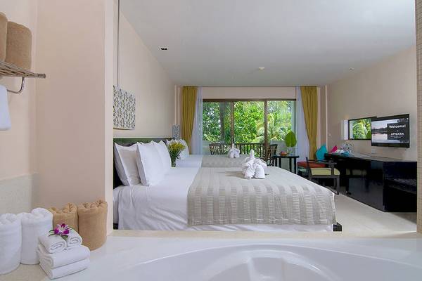 Schlafzimmer im Apsara Beachfront Resort and Villa mit zwei Betten, Whirlpool und Fernseher.
