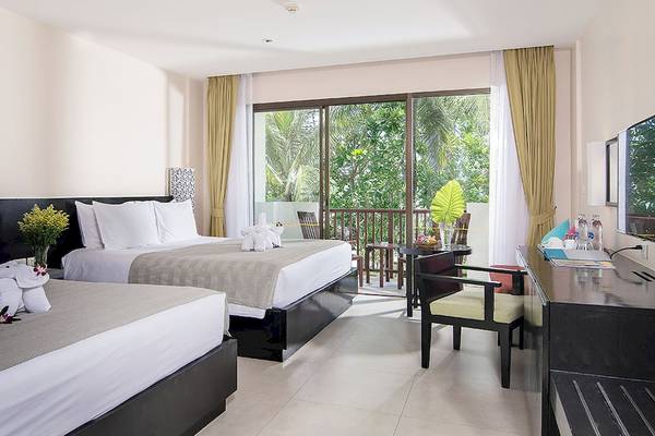 Doppelzimmer im Apsara Beachfront Resort und Villa mit zwei Betten, Balkon und Gartenblick.