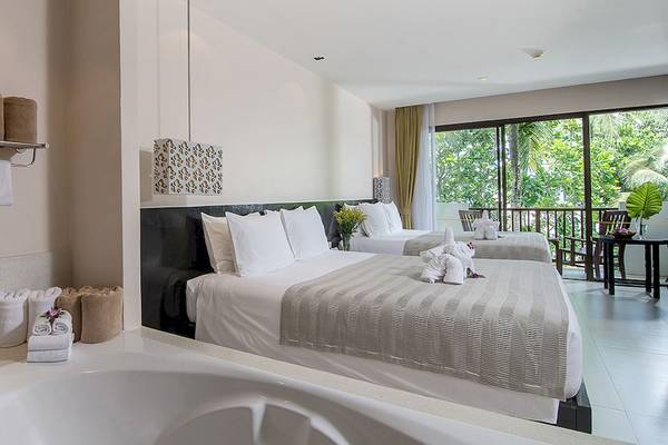 Schlafzimmer im Apsara Beachfront Resort and Villa mit zwei Betten, Whirlpool und Balkon.