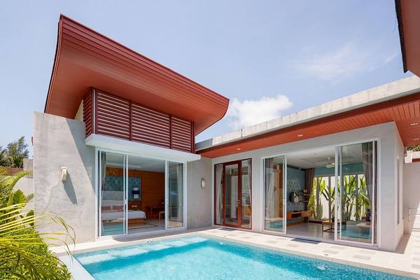 Außenansicht des Apsara Beachfront Resorts und Villa mit Swimmingpool und modernen Möbeln.