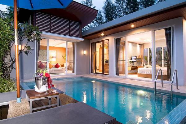 Außenbereich des Apsara Beachfront Resort und Villa mit Pool und Sonnenliegen.