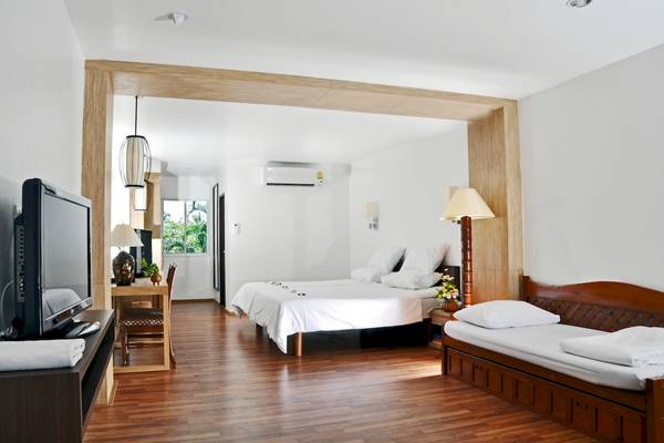 Innenansicht eines luxuriösen Zimmers im Best Western Phuket Ocean Resort mit zwei Betten, Fernseher und Möbeln.