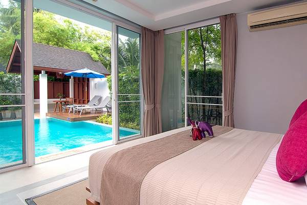 Schlafzimmer im Apsara Beachfront Resort and Villa mit Blick auf den Pool und Terrasse.