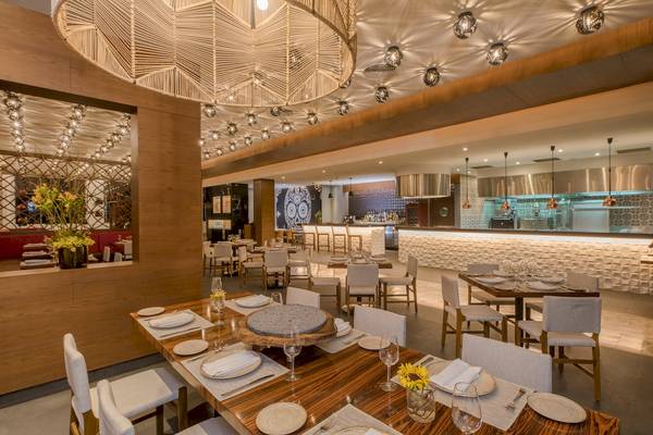 Innenbereich des Haven Riviera Cancun Resort & Spa mit Restaurant und Esstischen.