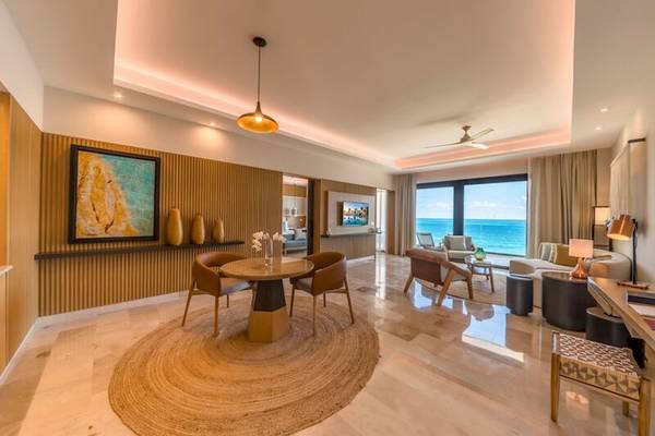 Innenraum des Haven Riviera Cancun Resort mit Esstisch, Sofa und Meerblick