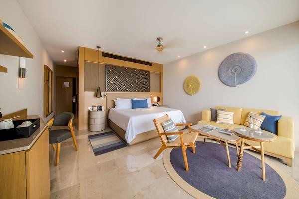 Hotelzimmer im Haven Riviera Cancun Resort & Spa mit Bett, Sofa, Tisch und Dekor