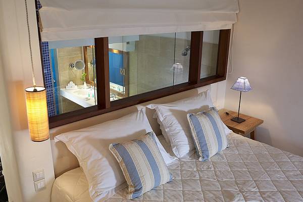 Ein Bett mit Kissen und Spiegel im St. Nicolas Bay Resort Hotel & Villas.