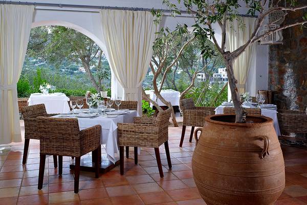 Terrasse des St. Nicolas Bay Resort Hotel & Villas mit Tisch und Stühlen