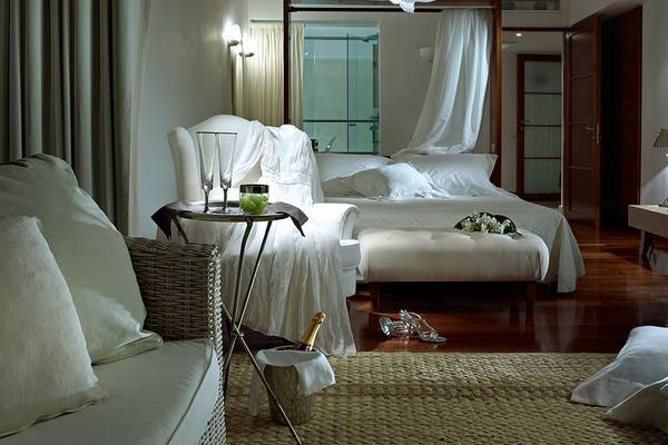 Schlafzimmer im St. Nicolas Bay Resort Hotel mit Bett, Nachttisch und Dekor