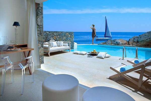 Terrasse des St. Nicolas Bay Resort Hotels mit Blick auf den Pool und das Meer.