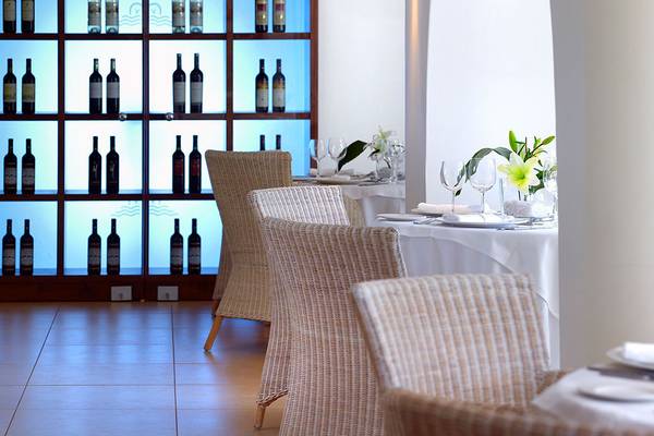 Restaurant des St. Nicolas Bay Resort Hotel & Villas mit eleganten Tischen und Weinen im Hintergrund