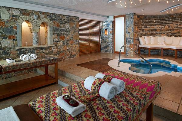 Spa-Bereich des St. Nicolas Bay Resort Hotel & Villas mit Massagetischen und Whirlpool.