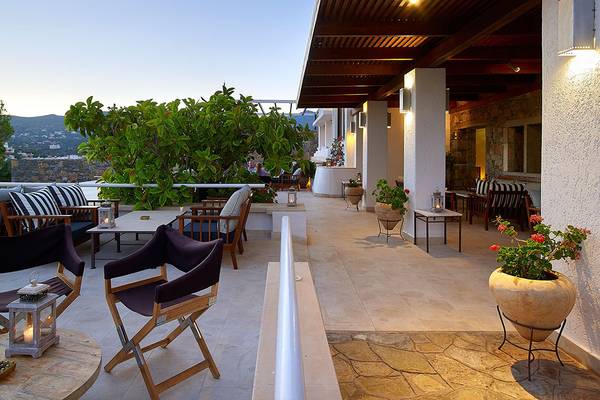 Terrasse des St. Nicolas Bay Resort Hotel & Villas mit Möbeln und Pflanzen