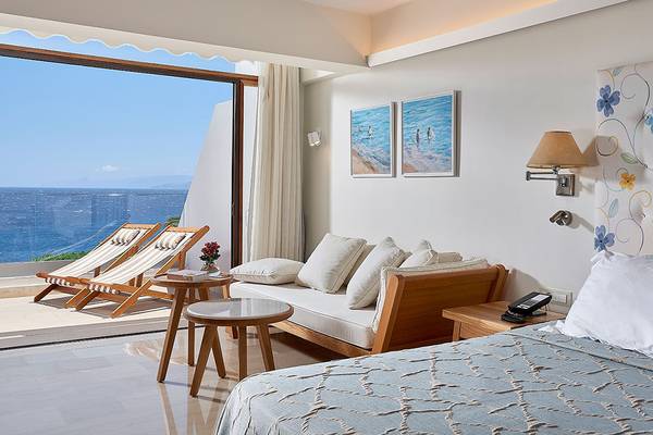 Innenansicht einer Suite im St. Nicolas Bay Resort Hotel & Villas mit Meerblick.