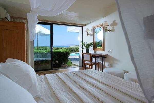 Schlafzimmer mit Blick auf den Pool im St. Nicolas Bay Resort Hotel & Villas