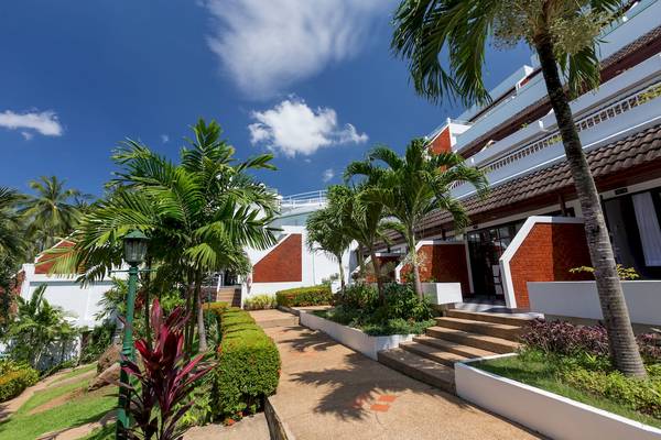 Außenansicht des Best Western Phuket Ocean Resort mit Bäumen und Pflanzen im Vordergrund.