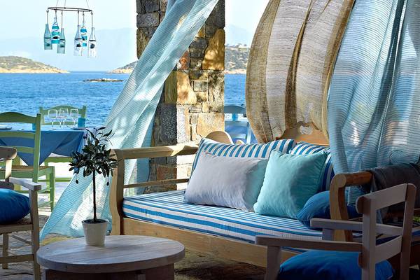 Terrasse mit Sofa und Tisch im St. Nicolas Bay Resort Hotel mit Blick auf das Meer.