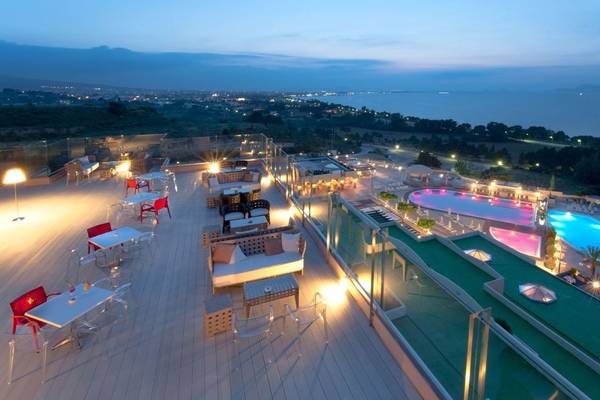 Aussicht auf die Terrasse des Kipriotis Panorama Suites Hotels mit Swimmingpool und Stadtansicht.