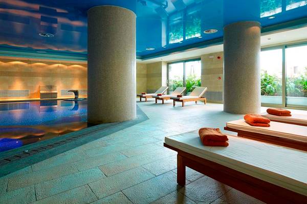 Innenpool des Royal Blue Resorts mit Liegen und blauen Deckenleuchten.