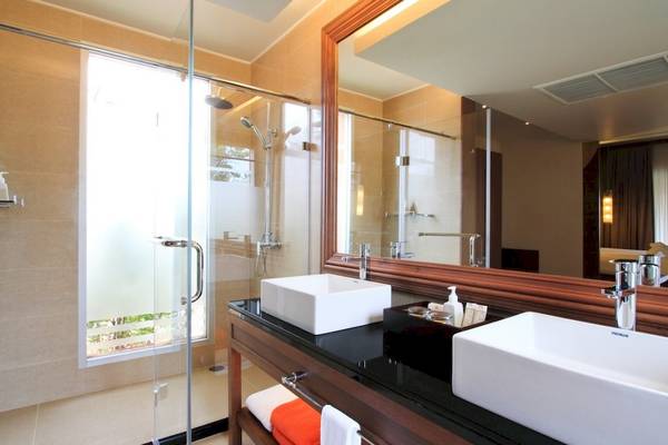 Badezimmer im Beyond Resort Khao Lak mit Glasdusche, zwei Waschbecken und einem Spiegel.